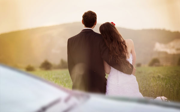 Wedding couple near car